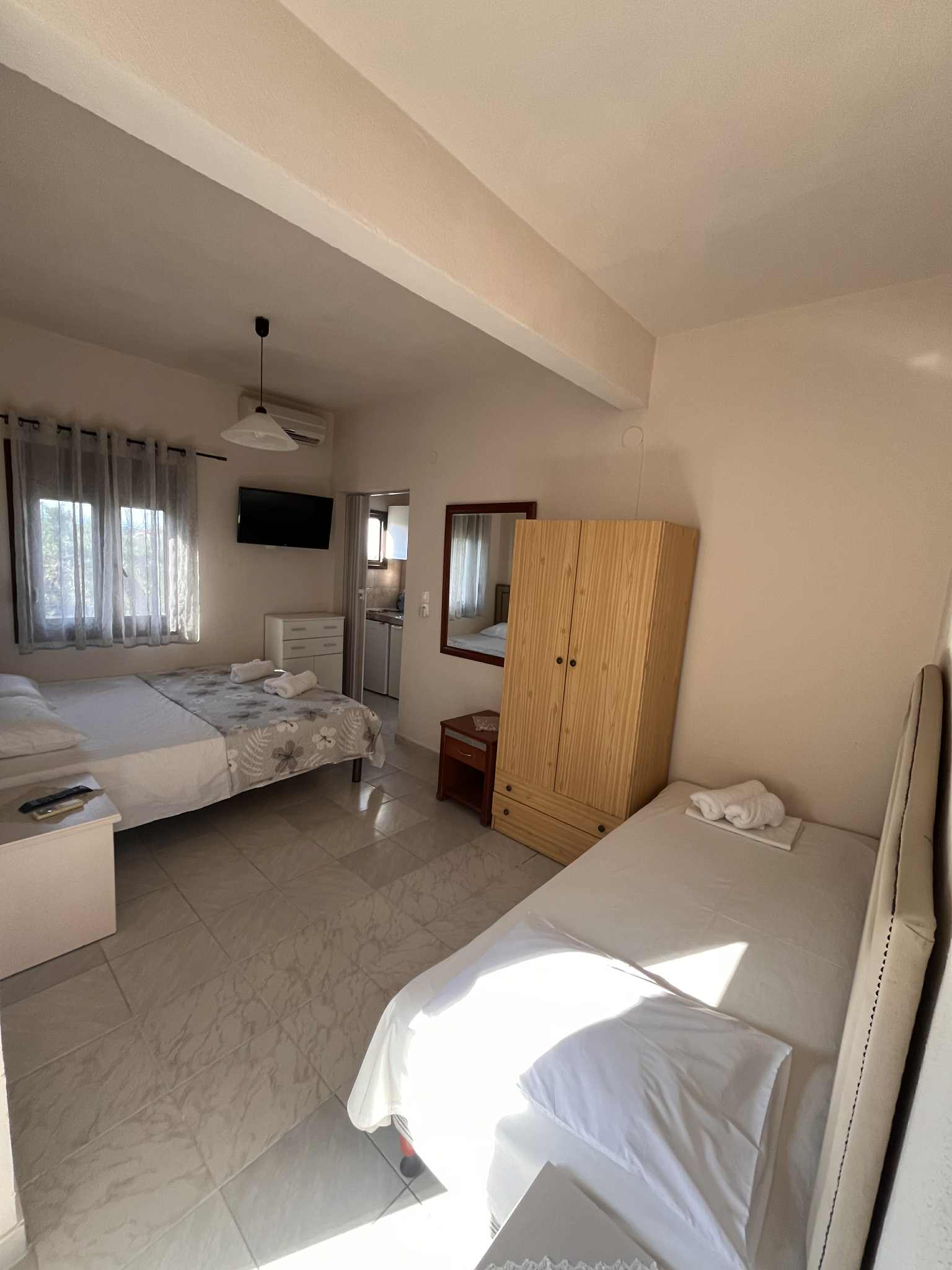 Single-room apartment with a double bed and a regular-sized bed.