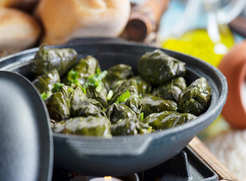 Delicious stuffed grape leaves served in a ceramic dish, perfect for a Mediterranean meal.